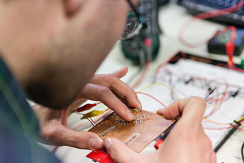 Student arbeitet an einer Platine